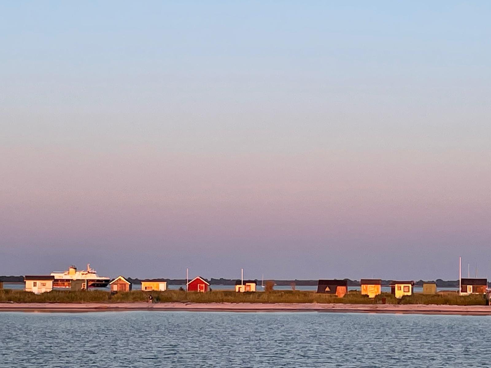 Kleurrijke huisjes op het strand van Ærø bij zonsondergang