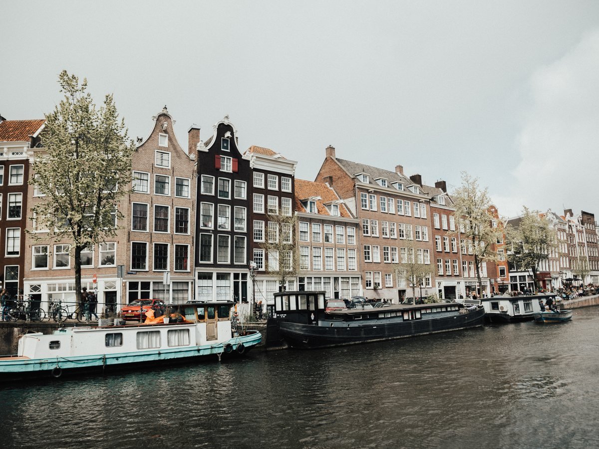 Grachtenpanden en woonboten aan een gracht in Amsterdam