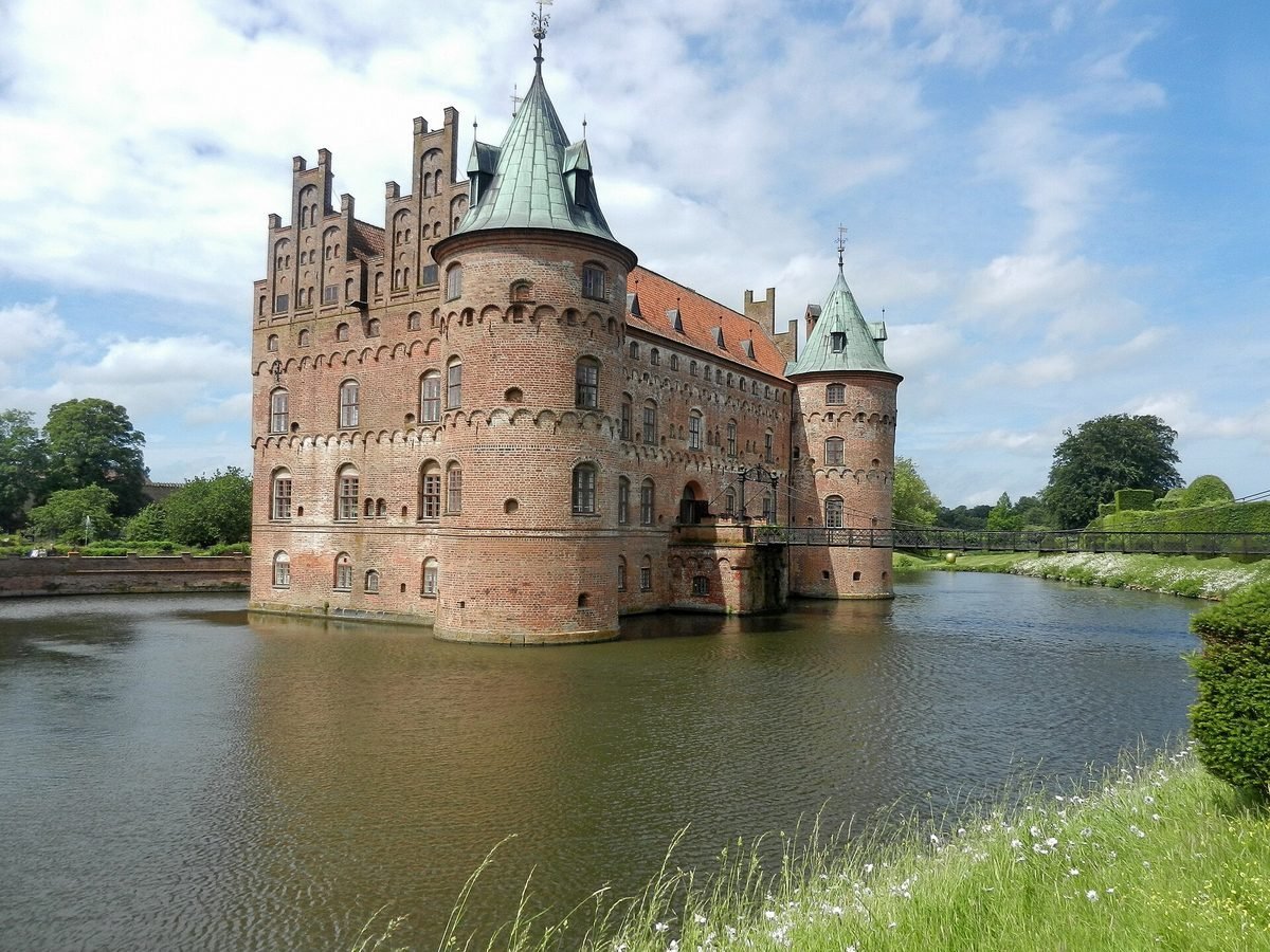 Waterkasteel Egeskov op Funen, weerspiegeld in de slotgracht