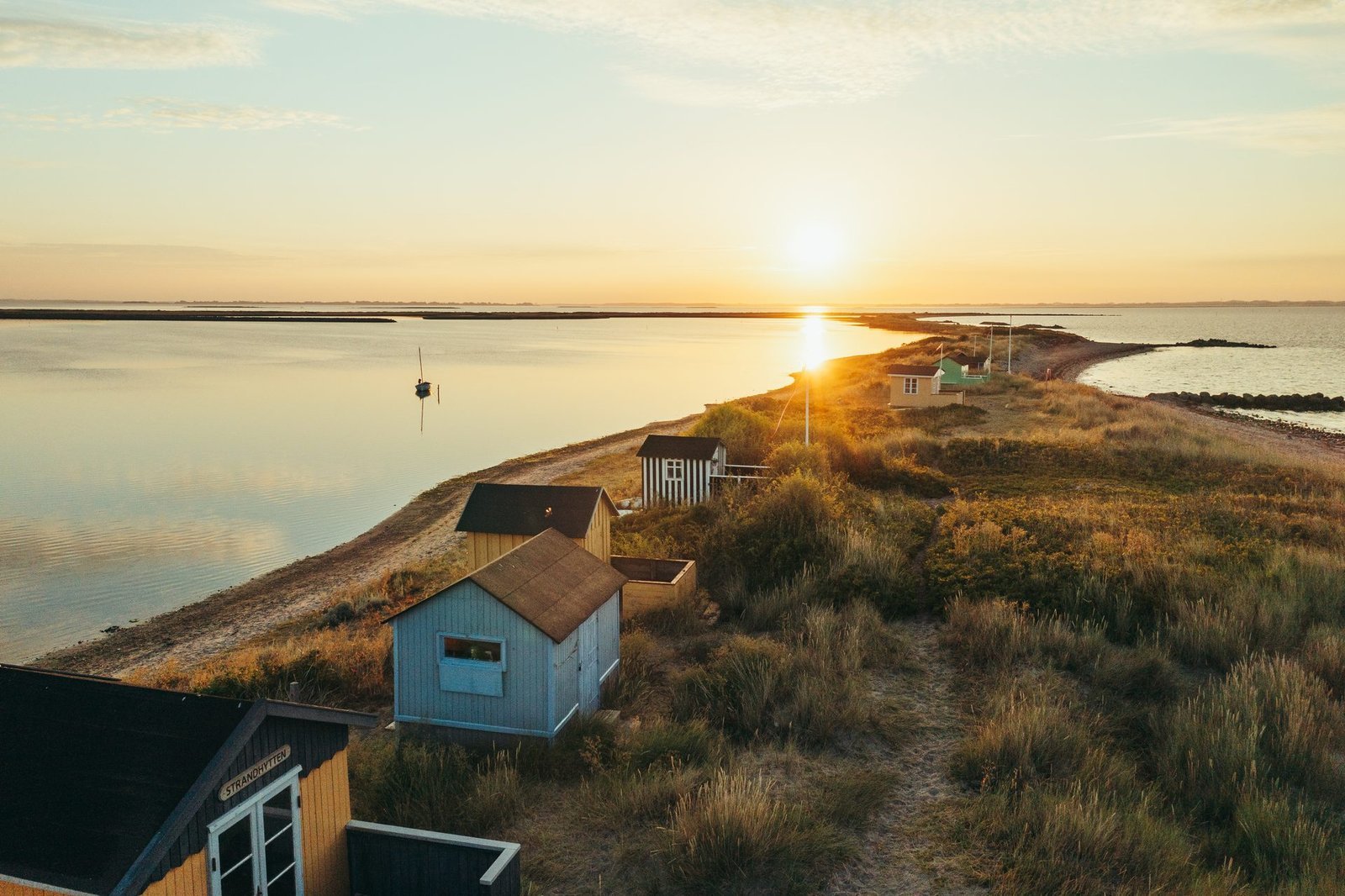 Kleurrijke badhuisjes op het strand van Marstal bij zonsondergang