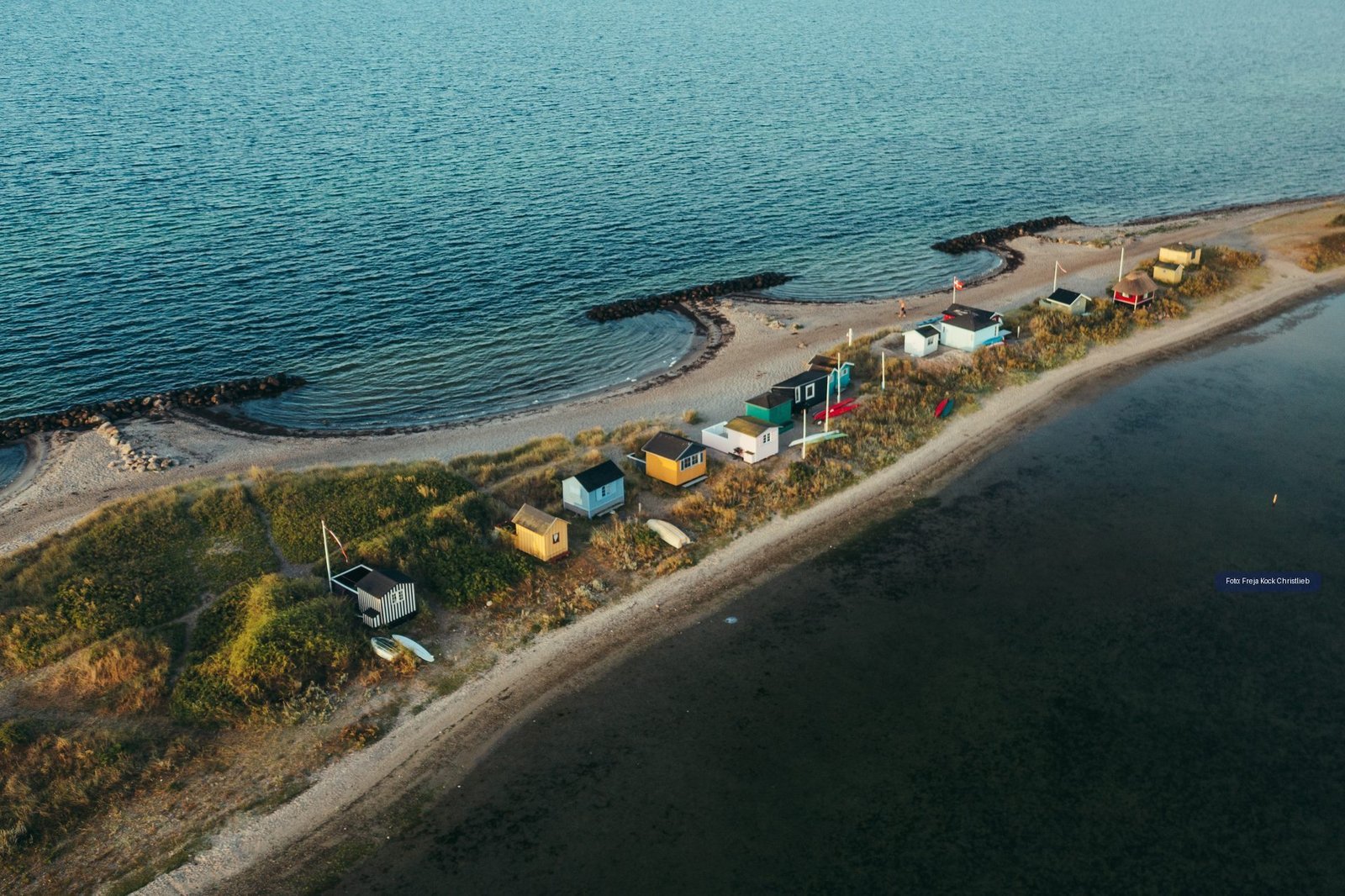 Luchtfoto van kleurrijke badhuisjes aan de kust van Marstal