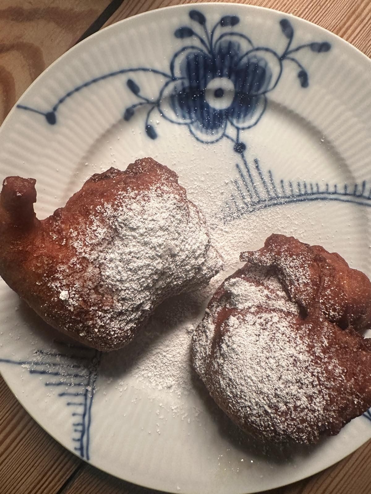 Twee Ærø-pannenkoeken met poedersuiker op een blauw gedecoreerd porseleinen bord